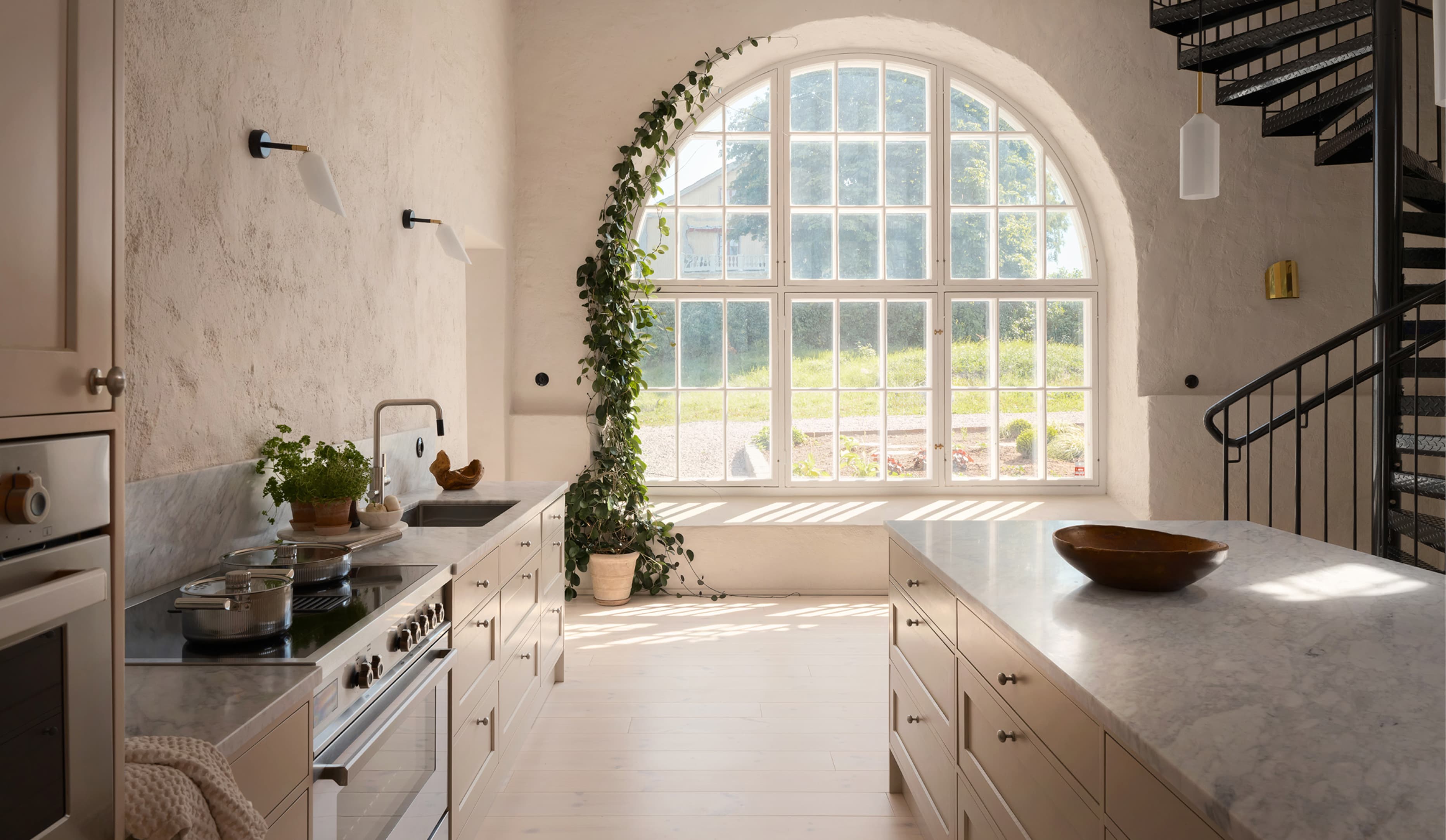LSBolagen case: range cooker in a bright kitchen with marble worktops and a large arched window